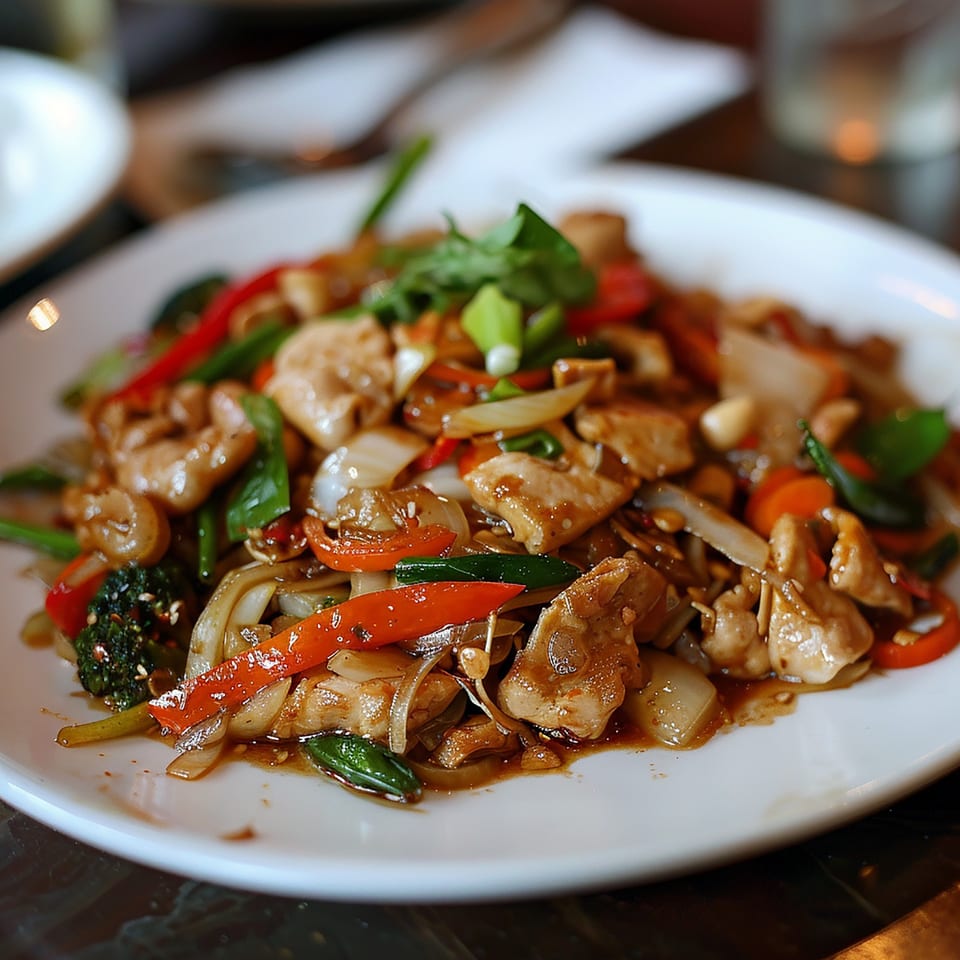 A close-up of Thai Chili's chicken stir-fry with colorful vegetables and a savory sauce.