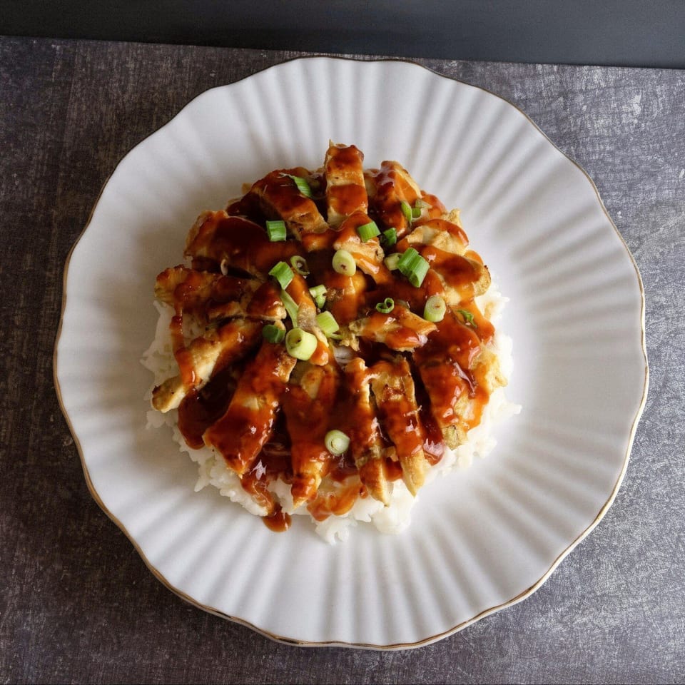 Thai Chili's chicken teriyaki, served over white rice and garnished with chopped green onions.